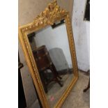 AN ANTIQUE CARVED GILTWOOD MIRROR