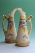 A pair of Royal Worcester ivory ground ewers, with hand painted floral decoration, 21cm high