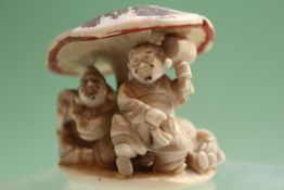 A late 19th Century Japanese carved ivory okimono, depicting figures beneath a toadstool, bears