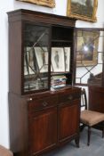 A George III mahogany bookcase cabinet, with astragal glazed doors over two drawers and panel