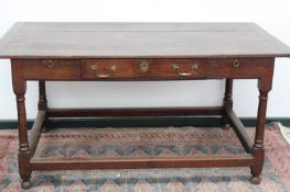 An 18th Century oak refectory table, the plank top with bread board ends, over drawer and