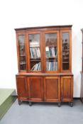 A 19th Century mahogany breakfront bookcase, the flared cornice above four glazed doors, the lower