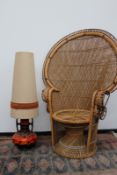 A mid Century cane peacock chair of good size, together with a German pottery floor lamp with
