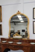 A large Victorian gilt framed overmantel mirror, of swept sided form