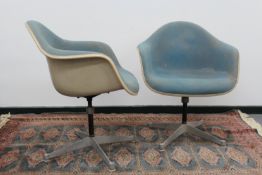 A pair of Herman Miller swivel adjustable fibreglass armchairs, with blue cloth upholstery wand