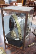 A vintage armour breast and backplate, contained in bronze framed display case