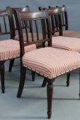 A set of six Georgian mahogany dining chairs, with reeded stick backs and over stuffed seats, on