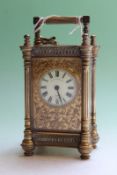 A late 19th Century French brass carriage clock, with pilaster decoration, cut card surround to