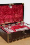 A late Georgian rosewood and brass inlaid dressing case, with fitted interior of twelve silver