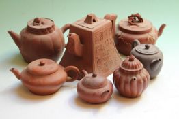 A Chinese terracotta teapot of tapered form, 12cm high, and six smaller terracotta teapots. (7)