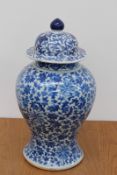 A Chinese blue and white covered baluster form temple vase, with over all scrolling foliage and