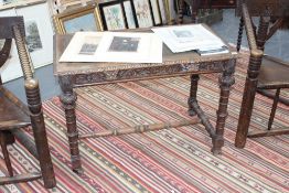 A Victorian carved oak writing table stamped Edwards and Roberts, inset leather top, apron drawer on