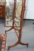 An early 19th Century mahogany cheval mirror, on sabre legs with brass castors, 186cm high