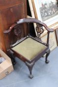 A George III mahogany corner chair with carved eagle head decoration, cabriole legs and claw and