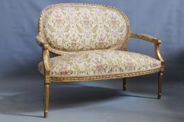 A French Louis XVI style salon settee, with carved gilt show frame, 125cm wide