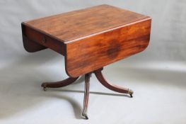 An early 19th Century mahogany pedestal pembroke table, on quadruple supports with brass castors