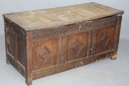 A 17th/18th Century oak panel coffer, with triple panel top over conforming base, carved frieze