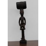 A carved ceremonial tribal staff finial of figural female form, possibly African, 61cm high.