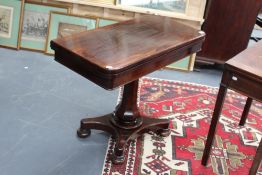 An early Victorian rosewood card table, with faceted pedestal, on platform base with bun feet,
