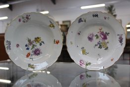 A pair of Meissen bowls decorated with hand painted spray of flowers, lillies, roses and forget me