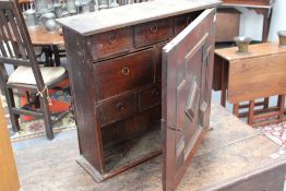 An early panelled oak spice cabinet, fitted with moulded panelled door and eight short drawers, 56cm