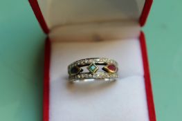 An 18ct white gold ring set with diamonds, rubies and sapphires