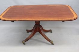 A Georgian mahogany breakfast table, with boxwood and rosewood banded tilt top over turned column