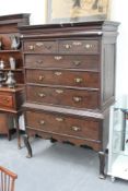 An 18th Century oak tall boy chest on stand, with shaped cornice and moulded frieze, over two