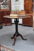 A Georgian mahogany birdcage tilt top table, with tapered pedestal on scroll legs with pad feet,
