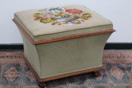 A Victorian box ottoman with beadwork upholstery, rising top over swept sided base, on bun feet with