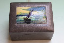 Liberty & Co: a pewter cedar lined cigarette box, inset with enamelled plaque depicting coastal