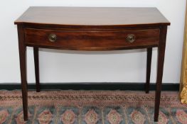 An antique mahogany and boxwood strung bowfront side table, with single drawer on square tapered