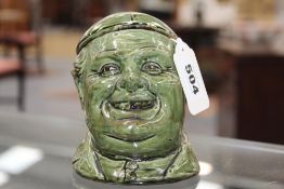 Ewenny Pottery: an unusual jar and cover in the form of a smiling man's head, the cover formed as
