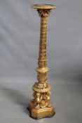 A carved and gilded torchere with winged beast supports, 137cm high