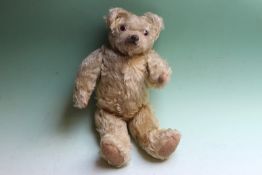 An early 20th Century teddy bear with jointed limbs probably by Farnell, 30cm high approx