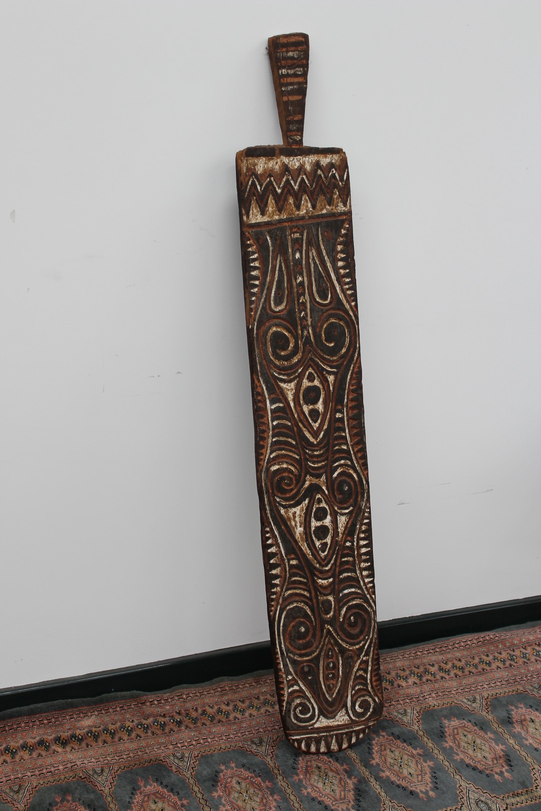 A carved and polychrome large shield, possibly African, 149cm high.