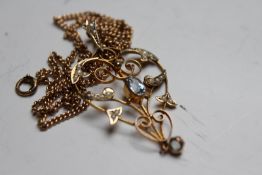 An Art Nouveau 9ct openwork pendant, set with zircon and seed pearls, on gilt chain