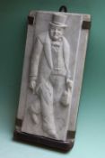 A rectangular carved marble plaque depicting Sir Winston Churchill carrying his gas mask, 31 x 15cm