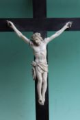 An antique carved ivory Corpus Christi, mounted on a ebonized cross, 36cm high over all