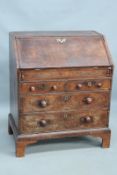 An 18th Century walnut and crossbanded bureau of small proportions, the fall front revealing stepped