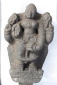 An antique Indian carved stone standing temple deity figure, 68cm high