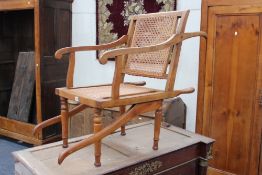 A late 19th Century Colonial beech John Carter's Patent campaign carrying chair, with caned seat and