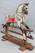 A vintage child's rocking horse: a dappled grey mounted on trestle form base, 114cm high x 128cm