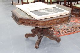 A Victorian carved oak octagonal library table, inset with gilt tooled green leather top, four apron