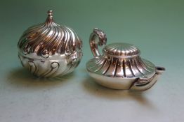 A Tiffany and Co. silver plated table light of Aladdin lamp form, and another of whorled form. (2)