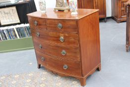 A mahogany late Georgian bowfront chest, with two short drawers above three long graduated