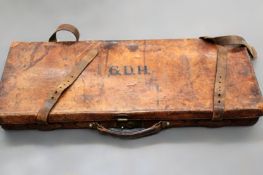 A vintage leather double shot gun case with Army and Navy trade label.