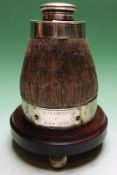 A rhinoceros horn inkwell with silver mounts and cover. On mahogany plinth and ball feet. 19cm high.