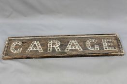 A vintage automotive “garage” sign. Painted pine. Each letter mounted with reflector insets.