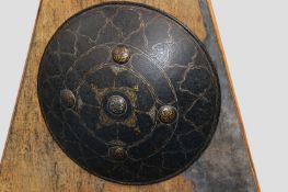 A Persian steel shield with etched and gilt highlighted decoration.